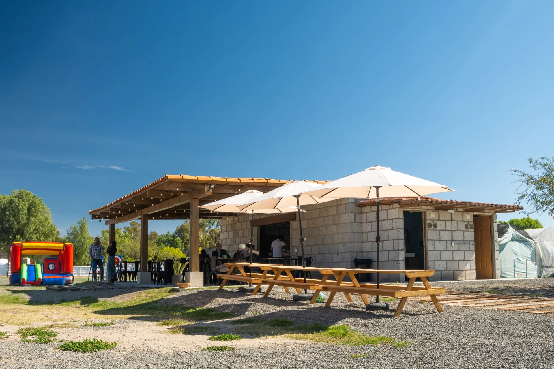 Terraza de Zerena con mesas, sombrillas e inflable bajo cielo azul