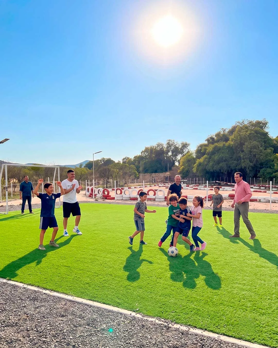 Niños y adultos jugando fútbol en la cancha de Zerena